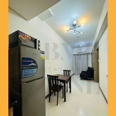 a kitchen and dining room with a table and a refrigerator at Staycation Manila at Coast Residences in Manila