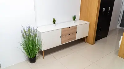 a white dresser with two plants in a room at Unistay SHELL Residence Amazing pool near MOA in Manila