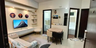 a living room with a couch and a tv and a mirror at 21K Pioneer Woodlands Mandaluyong in Manila