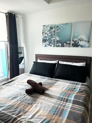 a teddy bear laying on top of a bed at Azure Staycation by Casa Lepap in Manila