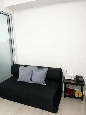 a black couch with two pillows in a room at Azure Staycation by Casa Lepap in Manila