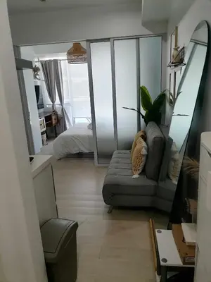 a living room with a couch and a bedroom at Luxury 1Bedroom Condo Unit Near Manila Airport - Azure Resort Residences in Manila