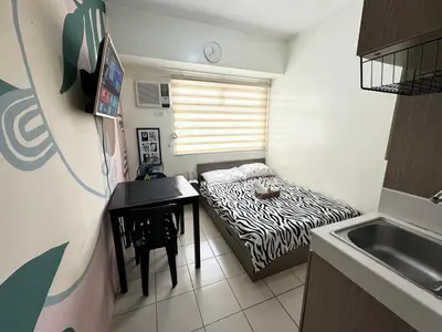 a small room with a bed and a desk and a sink at Studio in the Metro I Near MRT I WiFi in Manila