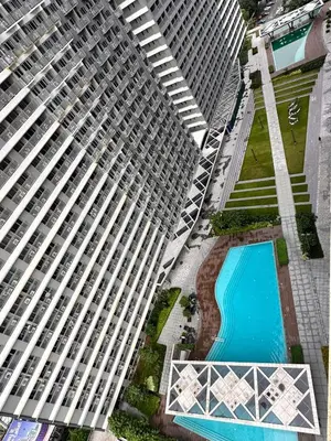 an overhead view of a tall building with a swimming pool at Cozy 1 BR in EDSA Mandaluyong in Manila