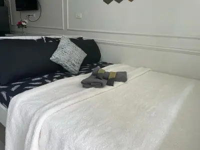 a bag sitting on top of a white bed at shore residences 1 -City Spark staycation in Manila