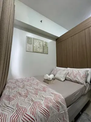 a bedroom with a bed with a striped comforter at Staycation bliss! Shore 2 B1! in Manila