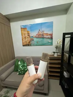 a person holding two wii controllers in a living room at Staycation bliss! Shore 2 B1! in Manila