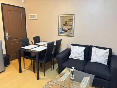 a living room with a table and a blue couch at Cozy 2BR Condo Free Pool Access in Manila