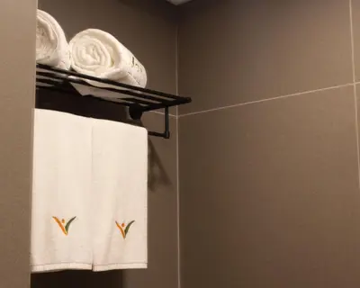 a bathroom with white towels on a towel rack at Novel Hotel Manila in Manila