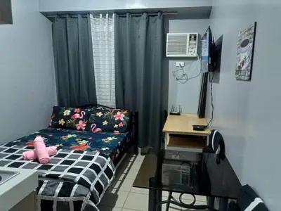 a small bedroom with a bed and a desk at Berto's Staycation Long Term and Short Term in Manila