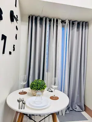 a white table with two glasses and a plant on it at hearth of ember 3 Shore 3 Res in Manila