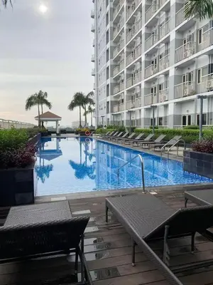 a swimming pool in front of a large building at FX Condotel 3322 in Manila