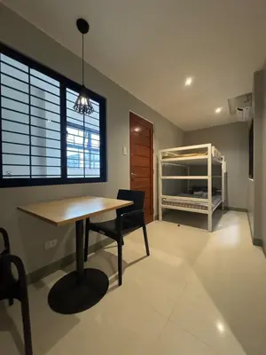 a dining room with a table and chairs and a bedroom at Santipha Residences in Manila