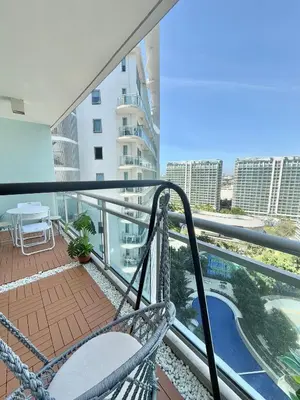 a balcony with a view of a swimming pool at 2BR - Azure Staycation Parañaque in Manila