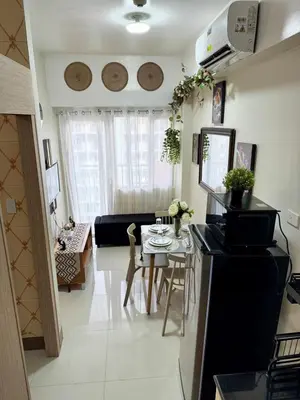 a living room with a table and a couch at 2BR Condo Staycation NearAirport in Manila