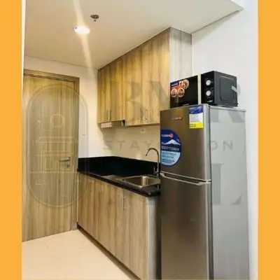 a kitchen with a stainless steel refrigerator and a sink at Staycation BMR Mnl at Coast Residences in Manila