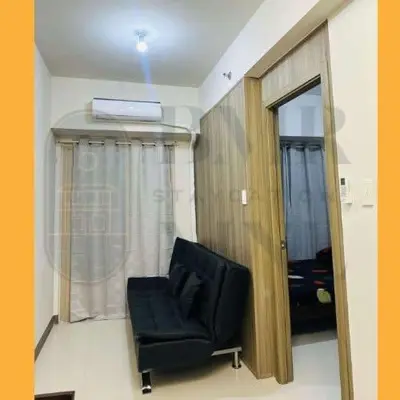 a black chair in a room with a window at Staycation BMR Mnl at Coast Residences in Manila