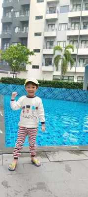 a young boy wearing a hat standing on a sidewalk at Charles Haven's Crib - Spring Residences in Manila