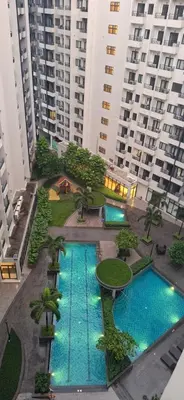 an overhead view of two pools in a building with tall buildings at Charles Haven's Crib - Spring Residences in Manila