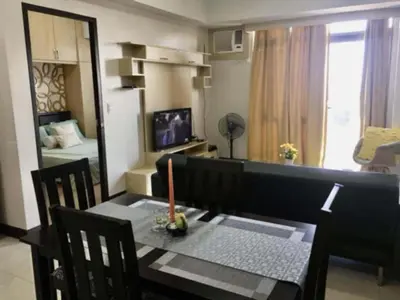 a dining room with a table and a room with a bedroom at Unit 14E Tower D, 1BR Unit- Manhattan Heights Cubao in Manila