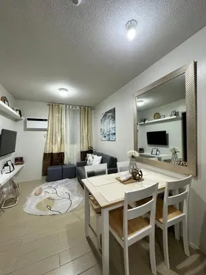 a living room with a table and a living room with a couch at 2 bedroom unit near BGC Taguig and NAIA Airport in Manila