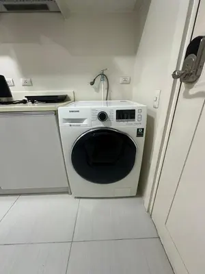 a kitchen with a washing machine in a room at Lugar Kalinaw in Manila