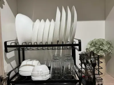 a shelf with plates and utensils in a kitchen at Einjel's Hideaway in Manila