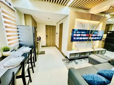 a living room with a table and chairs and a television at Royal Fame Residency in Manila