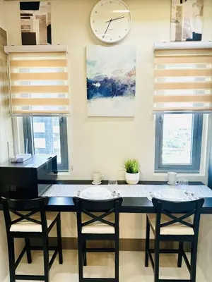 a kitchen with two chairs and a large clock on the wall at Royal Fame Residency in Manila