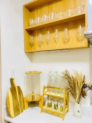 a kitchen with wine glasses and a shelf with jars at Staycation by Mailine in Manila