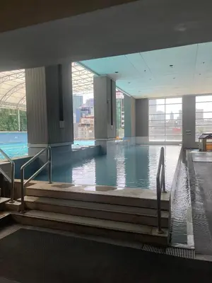 a large indoor swimming pool with water in a building at A Venue Residences Tower 12L in Manila