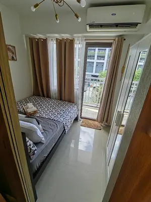 a small bedroom with a bed and a balcony at Mk Luxury Vacation in Manila