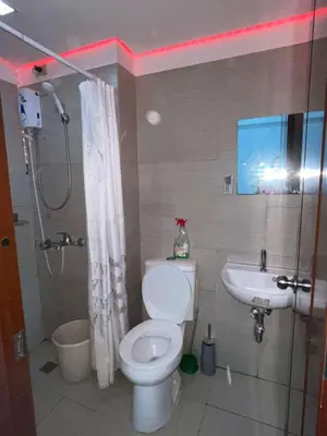 a bathroom with a toilet and a sink at Anuva Staycation by Gina in Manila