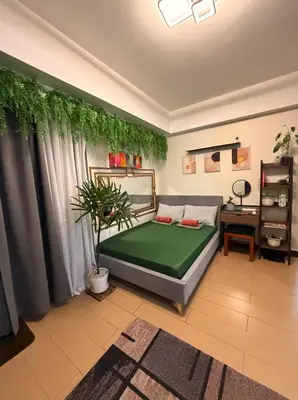 a bedroom with a bed with a plant on the wall at Casa Tagpuan at Manhattan Heights in Manila