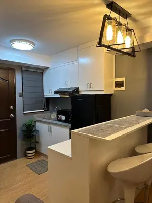 a kitchen with white cabinets and a counter top at H&D Suites-Memories are personal in Anabu Primero