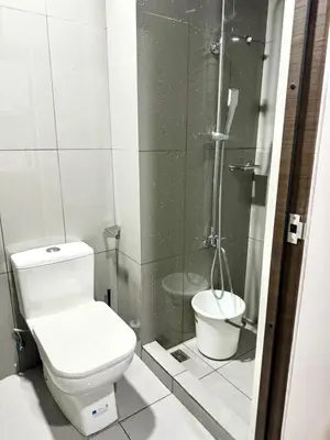 a bathroom with a toilet and a shower at Air Residence Makati in Manila
