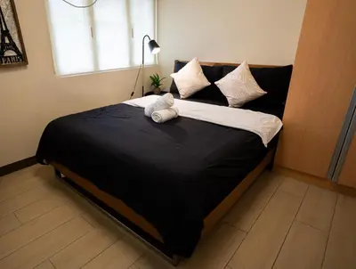 a teddy bear laying on a bed in a bedroom at Elegant unit, fast wifi, near Makati Medical Centr in Manila