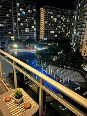 a balcony with a view of a city at night at Azure Staycation by Zette in Manila