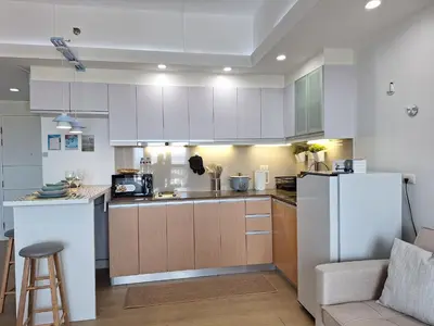 a kitchen with white cabinets and a white refrigerator at Luxury Coastal Suite, Grand Canal view in Manila