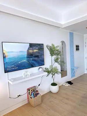 a living room with a flat screen tv on a wall at Luxury Coastal Suite, Grand Canal view in Manila