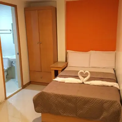 a bedroom with a bed with two towels on it at Stone House Hotel Pasay in Manila