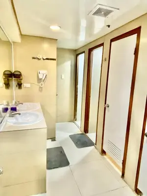 a bathroom with a sink and a mirror at Stone House Hotel Pasay in Manila