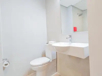a white bathroom with a toilet and a sink at Red Planet Makati Amorsolo in Manila