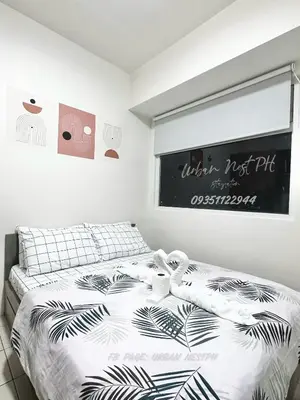 a bedroom with a bed and a window with a sign at Jam Reid Condotel Mandaluyong in Manila