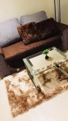 a living room with a couch and a glass table at Upscale 1Bedroom Condo Unit Near Manila Airport in Manila