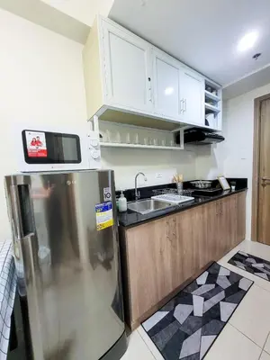 a kitchen with a stainless steel refrigerator and white cabinets at An-Dy's Point, Field Residences in Manila