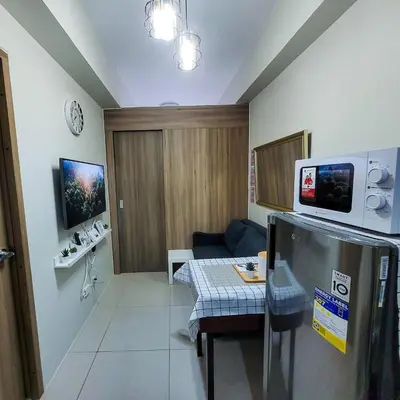 a living room with a couch and a table at An-Dy's Point, Field Residences in Manila