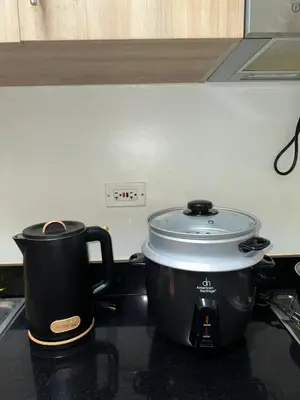 a pot sitting on top of a stove with a cup at Mall of Asia Vermilion Grand Suite in Manila