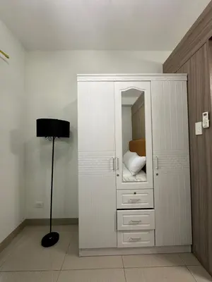 a bedroom with a large white cabinet with a mirror at Mall of Asia Vermilion Grand Suite in Manila
