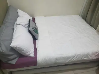 a bed with white sheets and pillows on it at La Luz 0835 Smdc Breeze in Manila